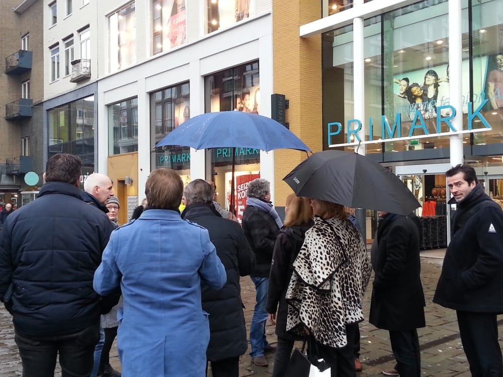 In de regen luisteren naar het succes van de Primark, eveneens aan Plein 44